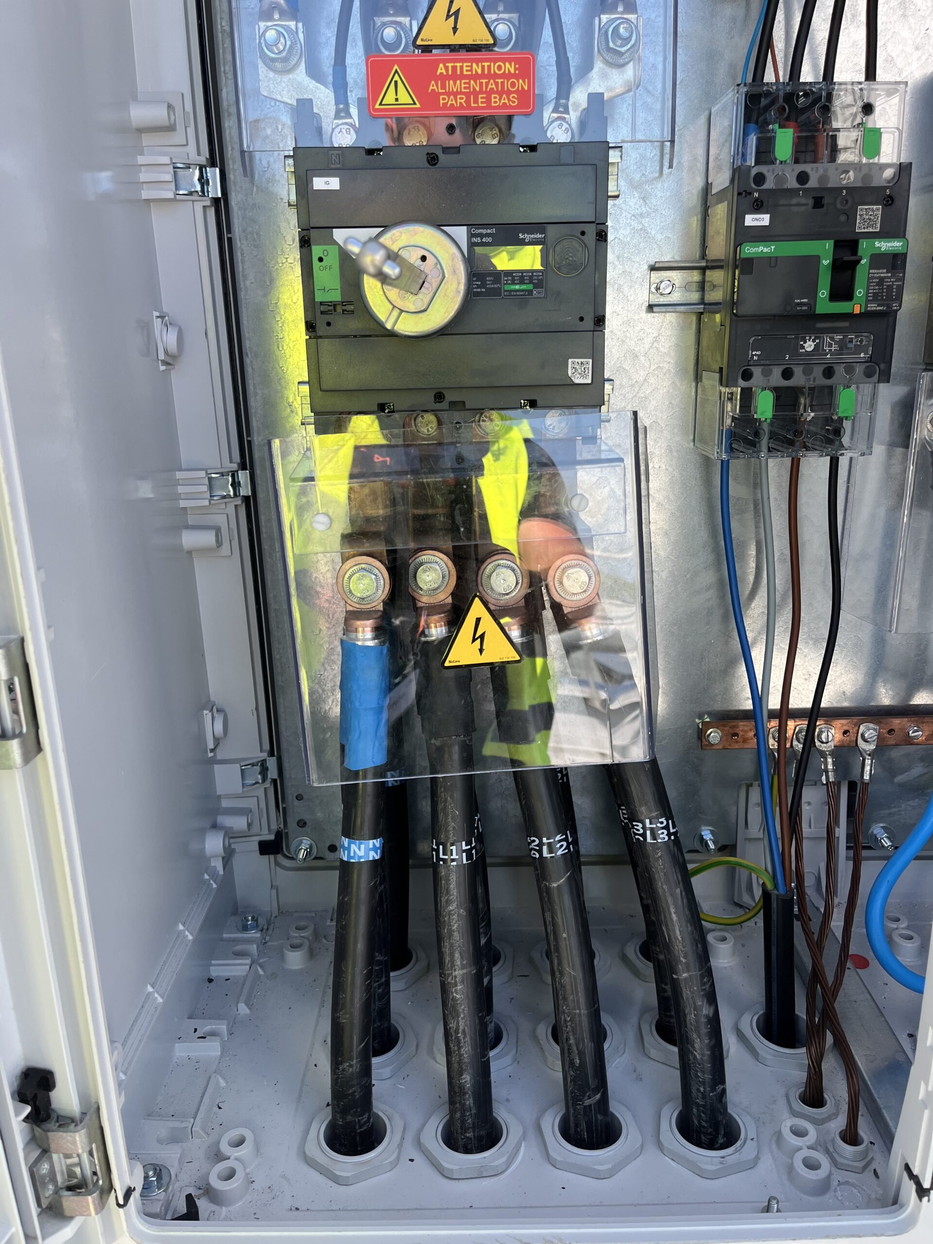 Électricien raccordant une armoire photovoltaïque en Vendée avec équipements de protection et onduleur solaire.