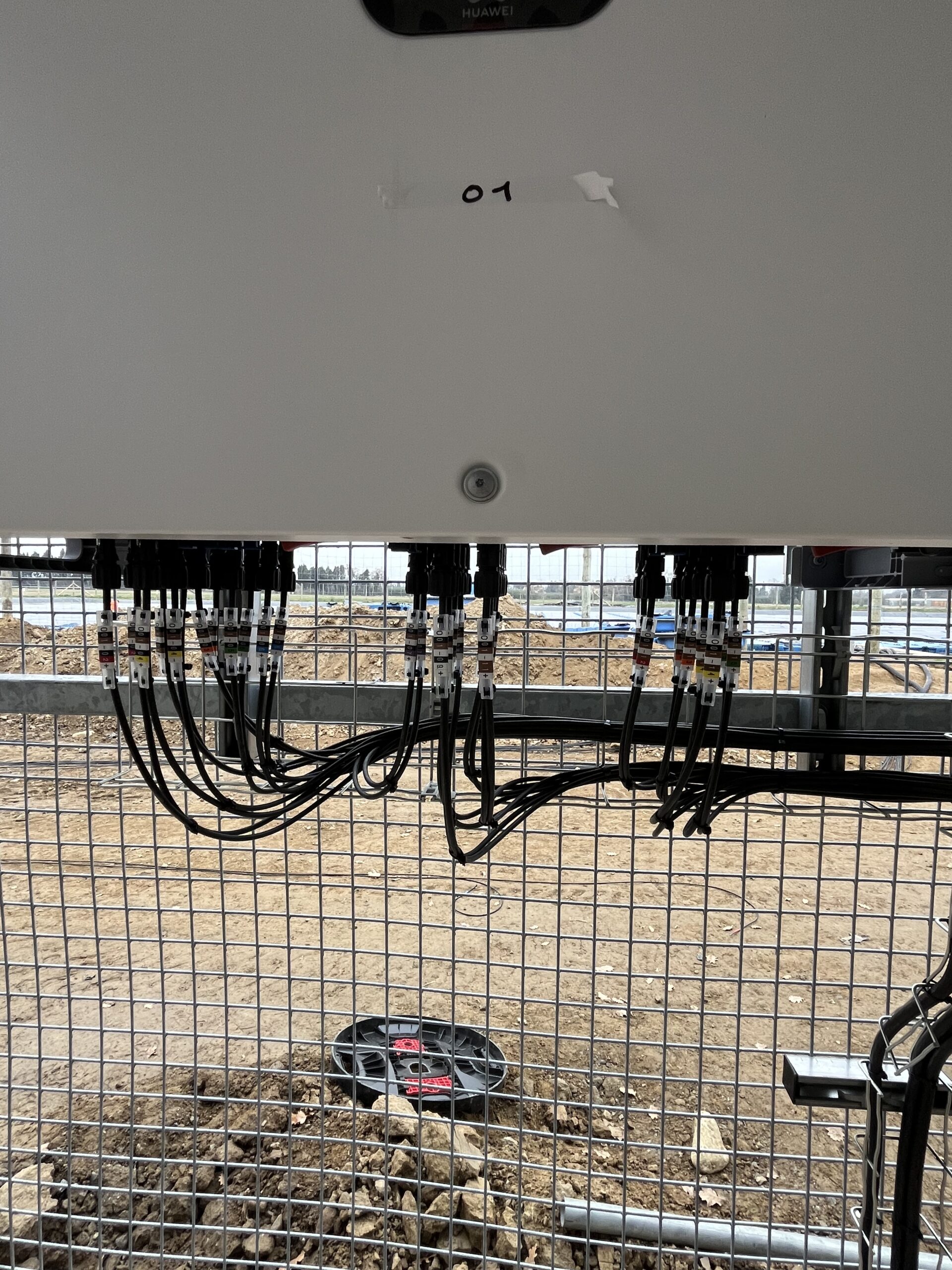 Électricien procédant au raccordement AC d’un onduleur Huawei 100KTL dans une centrale solaire industrielle à Perpignan
