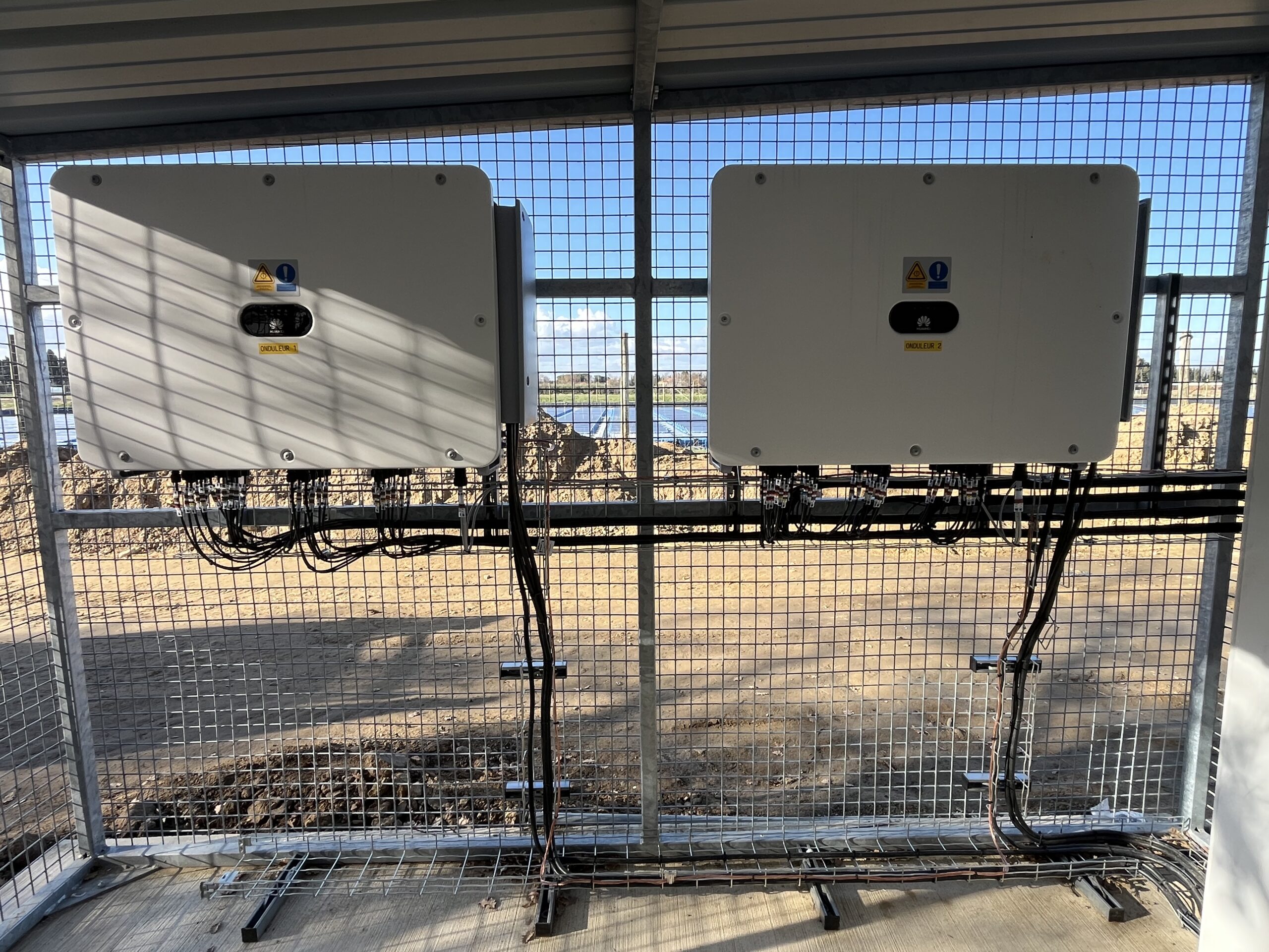 Électricien Perpignan 66000 en train de raccorder un onduleur à une installation photovoltaïque flottante, avec coffrets étanches et câblage sécurisé en zone humide.
