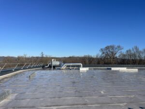 Électricien à Brive 19 inspectant un tableau électrique industriel vétuste dans un entrepôt logistique.